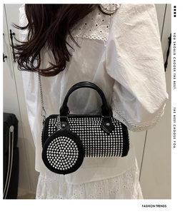 Détail du sac cylindrique noir avec clous argentés et petit porte-monnaie rond assorti