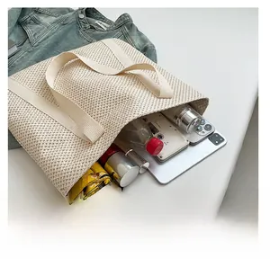 Capacité intérieure du sac cabas en paille beige avec parapluie, tablette et objets