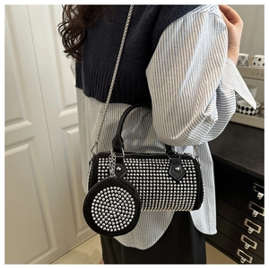 Détail du sac cylindre noir avec clous argentés et mini porte-monnaie rond