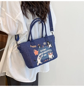 Detailed view of dark blue denim tote bag with cute cat and dog cartoon prints