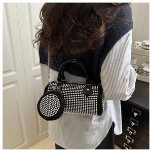 Détail du sac Boston noir à clous avec petit porte-monnaie rond et chaîne métallique