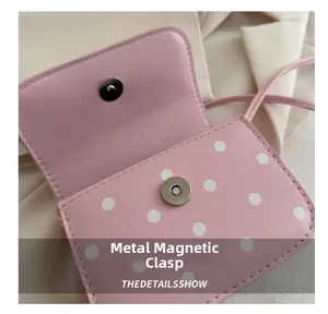 Close-up of pink polka dot handbag featuring a premium silver magnetic clasp and fine stitching