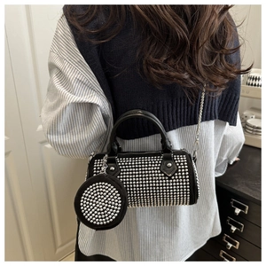 Détail du sac cylindrique noir avec rivets argentés et petit porte-monnaie assorti