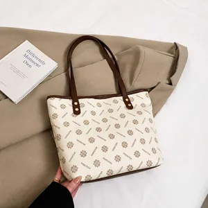 Detail of vintage monogram tote bag with brown leather handles and golden rivets