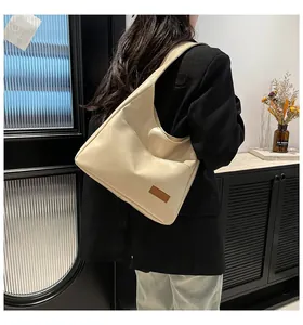 Detail of cream white PU leather hobo bag with external pocket and logo patch