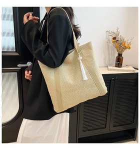 Détail d'un grand sac cabas en paille tissée avec accessoire de gland à franges blanc