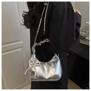 Silver metallic hobo bag featuring pearl bow charm and pleated handle detail