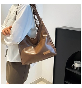 Detail of deep brown faux leather hobo bag showing spacious design and smooth texture