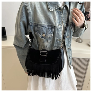 Détail d'un sac besace vintage noir avec franges superposées et boucle en métal argenté
