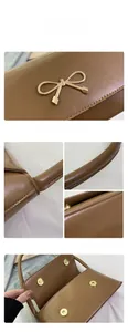 Détails du sac en similicuir marron avec nœud doré et fermeture magnétique pratique