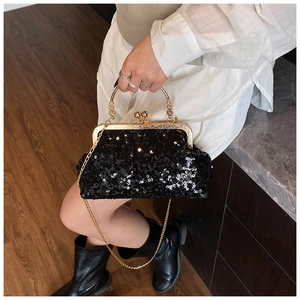 Macro detail of black sequined evening bag with vintage gold clasp and metal handle