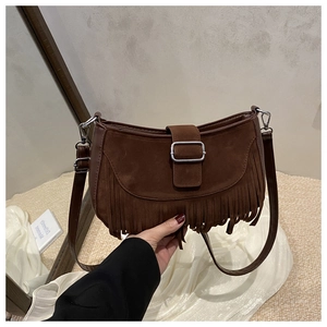 Détail d'un sac besace vintage marron foncé avec franges et boucle métallique argentée