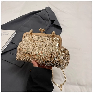 Detailed close-up of golden sequin evening clutch bag with round metal handle and clasp