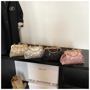 Detail of sequined evening clutch bags in four colors with round metal handles on display