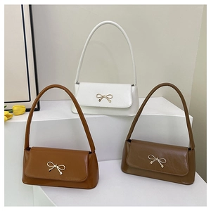 Sacs baguette à nœud en blanc, camel et café disposés sur des marches minimalistes