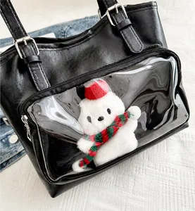 Detail view of large tote bag with transparent PVC pocket and white plush bear charm