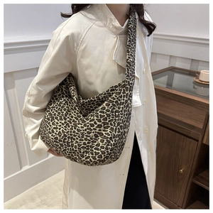 Close-up of leopard print canvas hobo bag on shoulder showing soft texture and large capacity