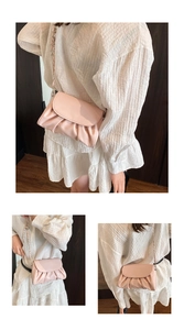 Macro detail of soft pleated leather and metal chain strap on light pink crossbody bag