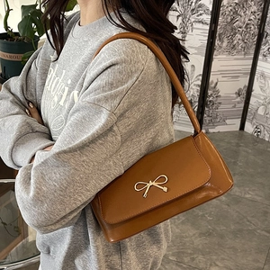 Sac baguette marron caramel avec boucle noeud doré sur cuir lisse élégant