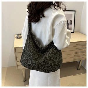 Chic leopard print canvas tote bag shown worn on shoulder with a stylish slouchy silhouette