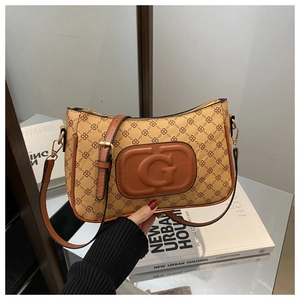 Detail showing vintage tan monogram texture with embossed G hardware and metal buckle