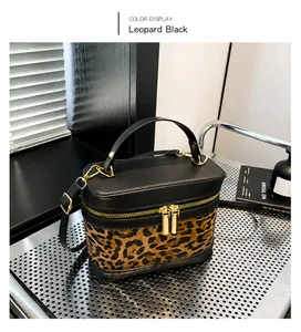 Détail du sac seau léopard avec finitions en cuir noir et fermeture éclair dorée