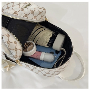 Interior view of white faux leather backpack showing storage for phone and umbrella