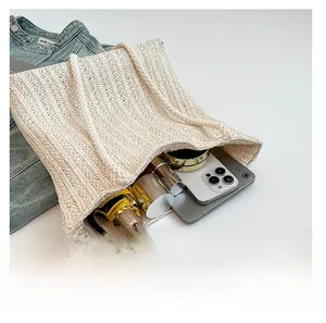 Detail showing the large interior capacity of this cream woven straw tote bag with essentials