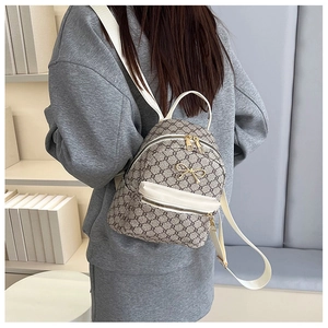 Rear view of a model wearing a mini retro backpack with grey pattern and gold hardware