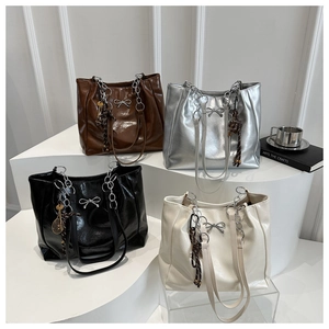 Detail view of large tote bags in four colors with metal bow and chain straps