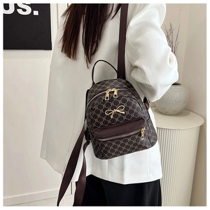 Detail view of vintage dark brown backpack with golden hardware and monogram pattern