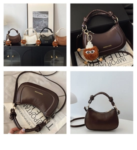 Detail of matte faux leather half-moon bag featuring knot handle and plush monster charm