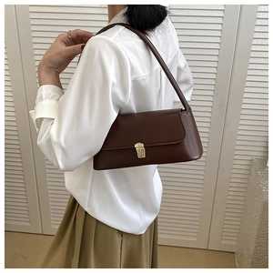Detail shot of the vintage dark brown leather baguette bag with a gold buckle clasp