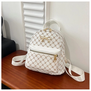 Close-up of geometric pattern texture and gold bow buckle on women's mini backpack