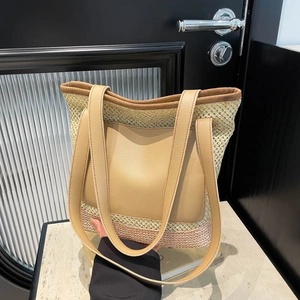 Straw and tan leather tote bag with large front pocket for beach and summer travel