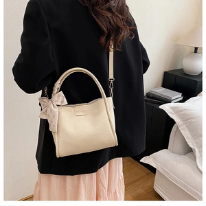 Detail of off-white lychee pattern leather tote bag with silk scarf and fashion buckle