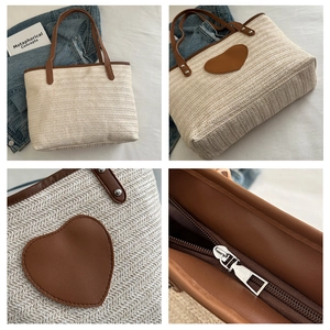 Close-up of woven tote bag with brown heart patch, leather handles and zipper detail
