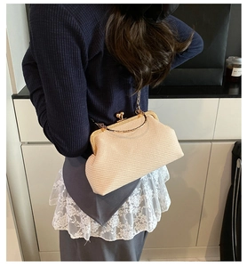 Détail du sac bandoulière tissé crème avec cadre vintage en métal doré et chaîne