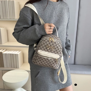 Classic monogram mini backpack with golden bow accent and white straps shown on model