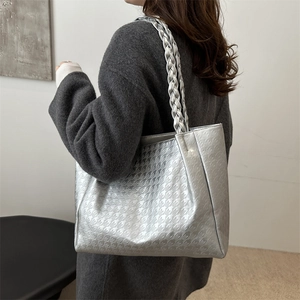 Silver houndstooth tote bag with braided straps shown on shoulder for daily commute