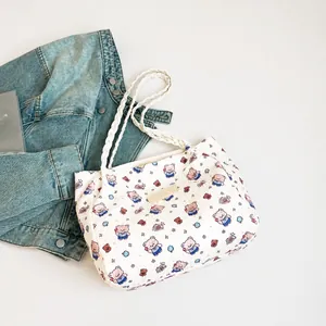 Detail of white tote bag featuring blue cartoon bear prints and textured quilted fabric