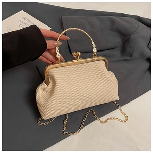 Détail du sac crème tissé avec poignée florale dorée et fermoir à boule vintage