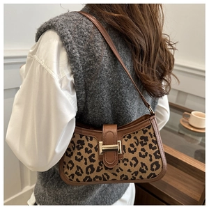 Détail du sac léopard avec garniture en cuir marron et boucle en métal doré chic