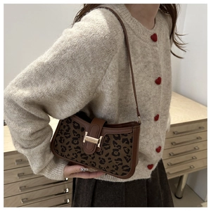 Détail du sac à bandoulière léopard vintage avec boucle métallique et bordure en cuir