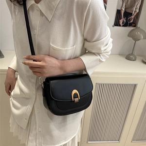 Classic black leather saddle bag for women with gold arch buckle and sleek crossbody strap