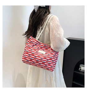 Detail showing red and white striped canvas tote bag with blue patterns and woven handle