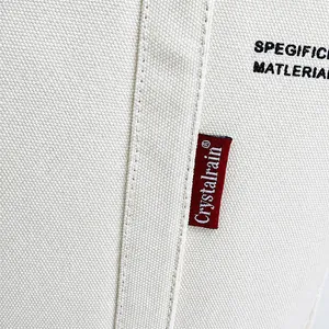 Nahaufnahme von weißem Canvas-Stoff mit rotem Markenetikett und feiner Nahtverarbeitung