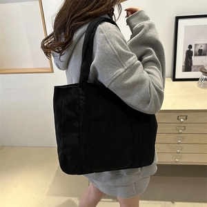 Classic black corduroy tote bag with wide straps shown on model for daily commuting