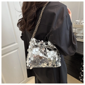 Detailed view of shimmering silver sequins and elegant gold chain on women's bucket bag