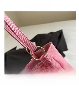 Close-up of pink striped canvas tote bag with gold metal ring connection detail
